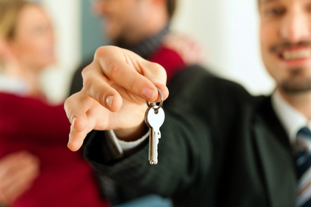 Young couple buying or renting a home or apartment, they are meeting the owner or real estate broker who has the keys